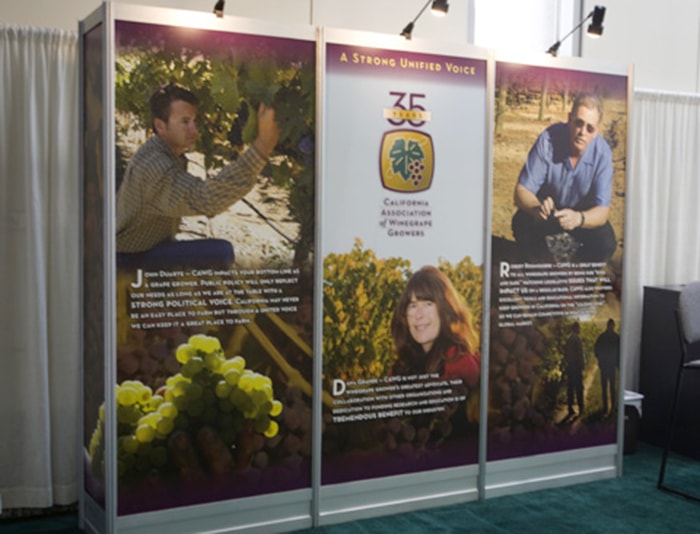 Trade show booth signage featuring three panels.